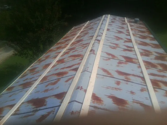 Rusted metal roof panels with new wood purlins before replacement — Storm Damage Roof Repair in Beaver Springs by Roofing Brothers