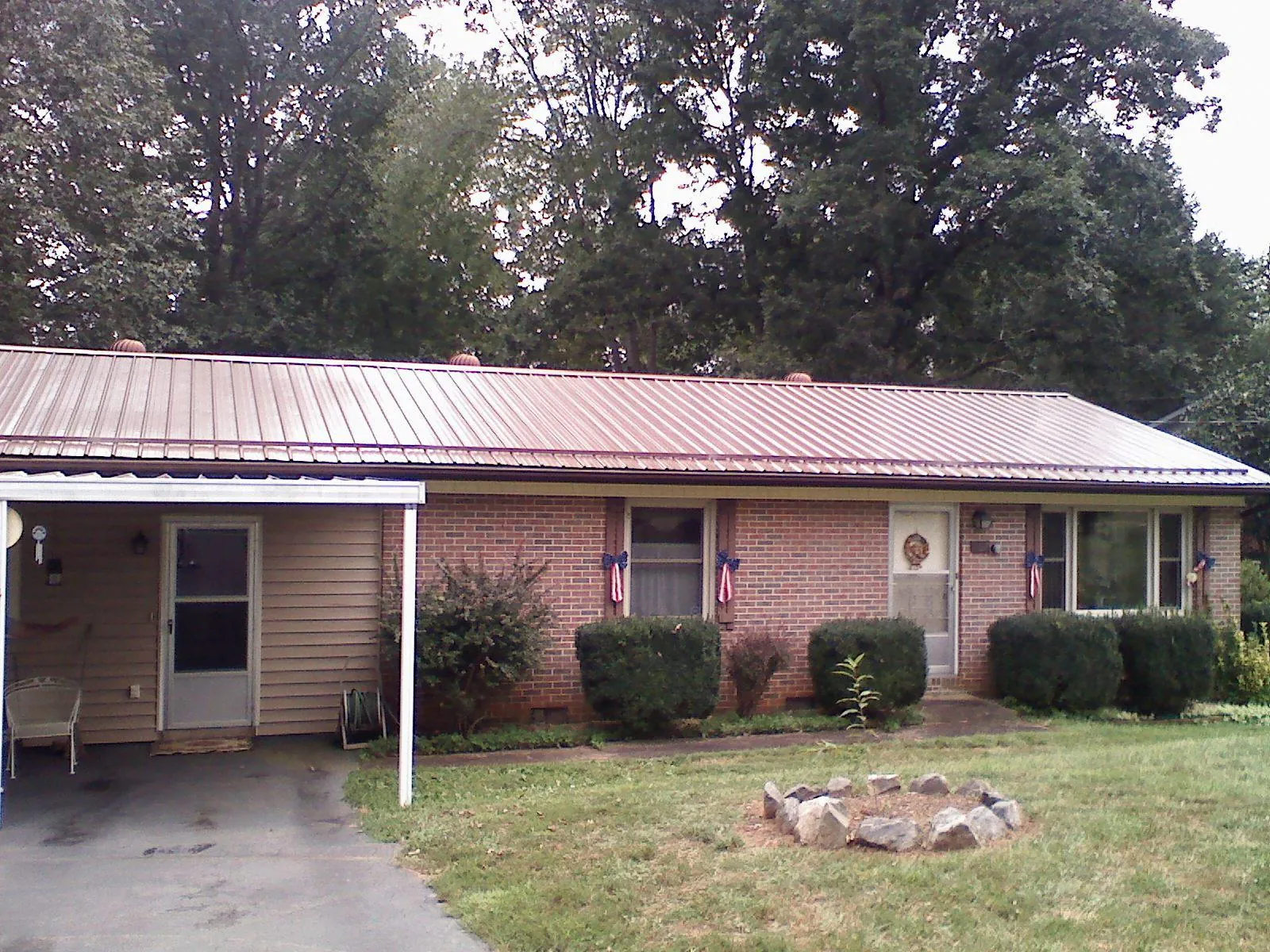 Bronze metal roof and carport on a brick ranch home — Roof Repair work by our crew in Beaver Springs